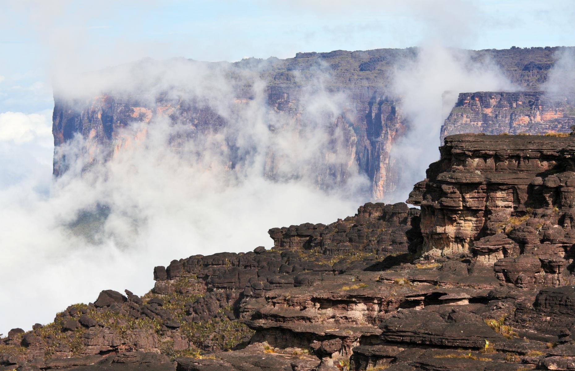 <p>One of the oldest mountain formations on Earth, the otherworldly Mount Roraima sits at the junction of the borders of Venezuela, Brazil, and Guyana. With its 1,300-foot-tall cliffs, often atmospherically shrouded in cloud, and its tabletop formation, it might seem like a floating island, but really it's a spectacular mountain dating back two billion years. Trekking to the top takes about six days, with incredible views and scenery along the way.</p>