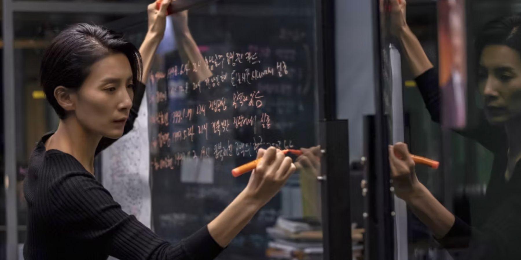 The detective writes notes on a clear dry erase board in Nobody Knows