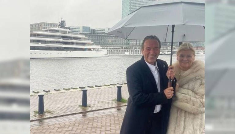Graeme Hart standing on an Amsterdam dock in front of the new superyacht.
