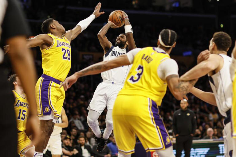 Mavericks guard Kyrie Irving (11) shoots over Lakers forward Rui Hachimura (28) Wednesday night at Crypto.com Arena. ((Robert Gauthier / Los Angeles Times))