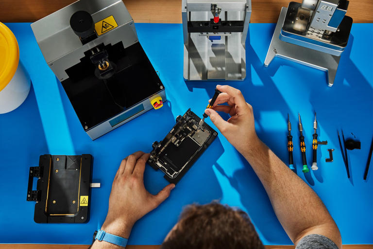 Person repairing an iPhone using Apple's Self Service Repair kit.