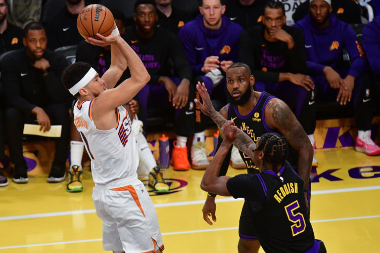 Phoenix Suns guard Devin Booker (1) shoots against Los Angeles Lakers forward Cam Reddish (5) and forward LeBron James (23) during the first half of the In-Season Tournament quarterfinal at Crypto.com Arena in Los Angeles on Dec. 5, 2023.