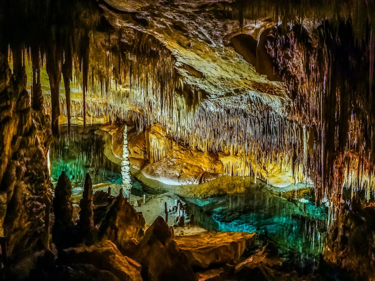 Scenic view of Barbados' most stunning caves, showcasing their majestic natural formations, stalactites and stalagmites, with soft illumination highlighting the intricate details and textures of the cave interiors.