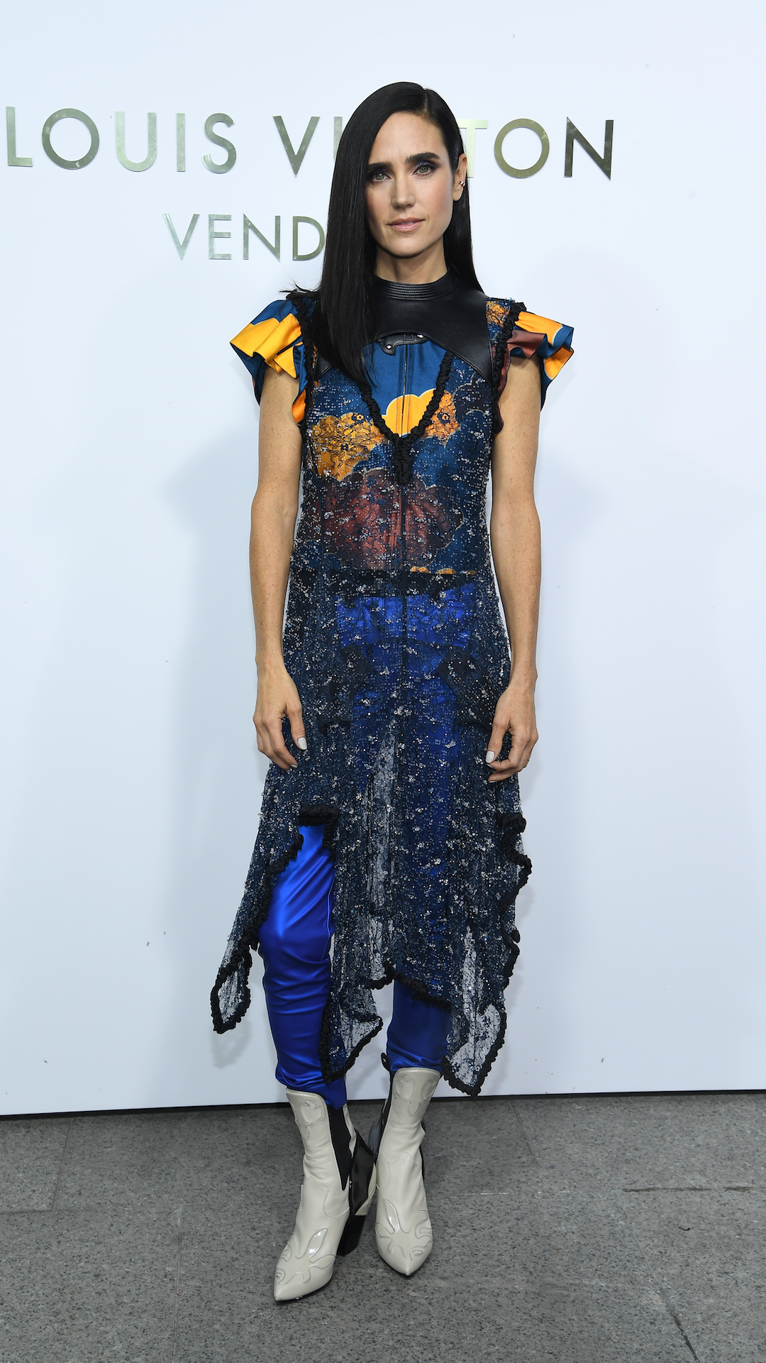 <p>                     Connelly isn't afraid to push fashion boundaries, and her adventurous style was on full display at the opening of the Louis Vuitton boutique during Paris Fashion Week in 2017. The actress wore a sheer black short-sleeved dress over a pair of shiny cobalt blue trousers, which she paired with a colourful top with ruffled shoulders. She finished off the quirky ensemble with a pair of white cowboy boots.                   </p>