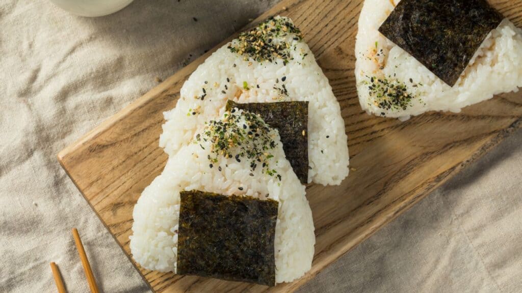 <p><span>Onigiri are Japanese rice balls, often wrapped in nori seaweed and containing a filling like salted salmon, pickled plum, or tuna mayonnaise. They're a popular, portable snack or meal known for their simplicity and the comforting taste of lightly salted rice.</span></p>