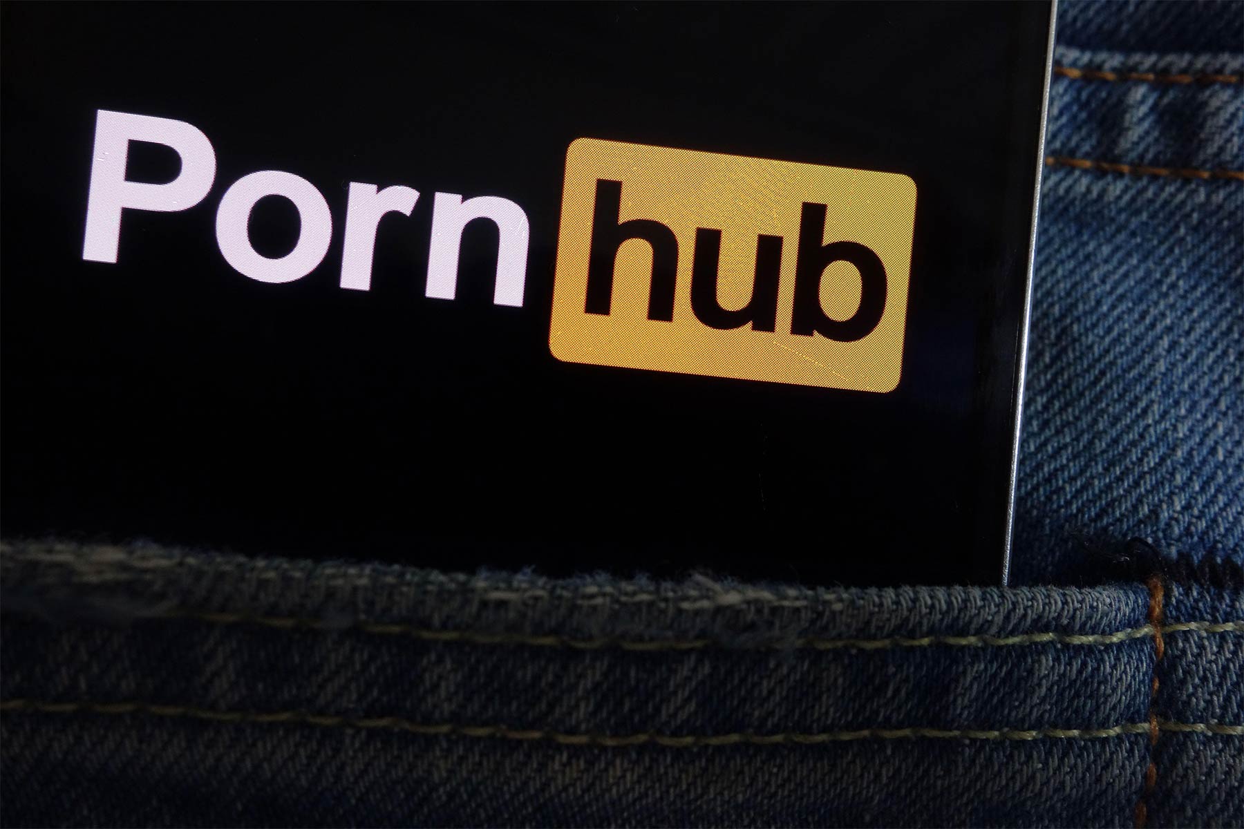 A photo of the Pornhub <b>logo</b> displayed on smartphone hidden in the back pock...