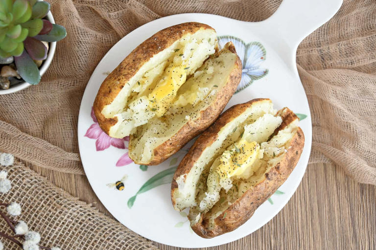 Baked whole potatoes topped with butter.