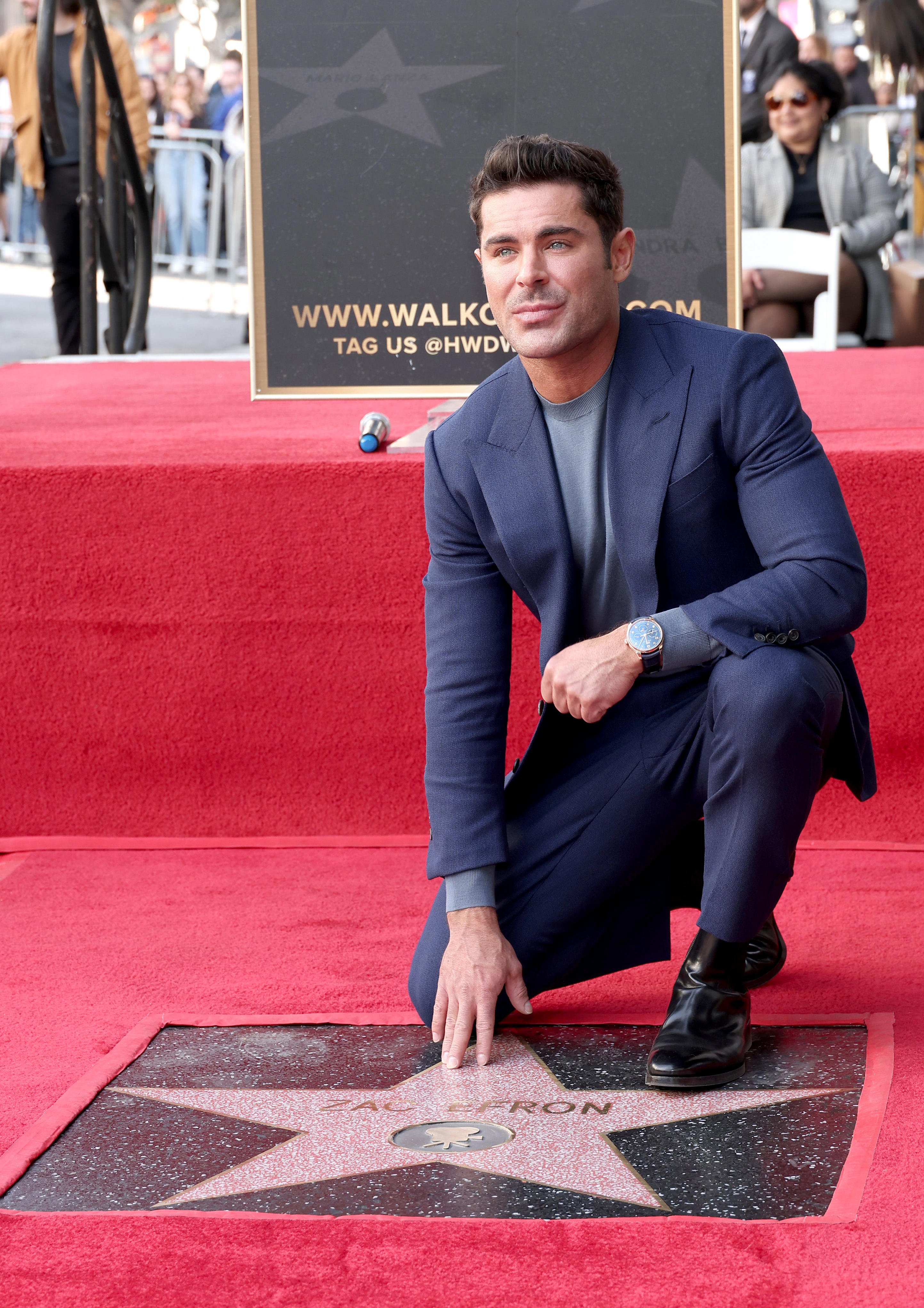 Zac Efron poses with his star during his Hollywood Walk of Fame Star Ceremony on Dec. 11, 2023 in Hollywood, California.