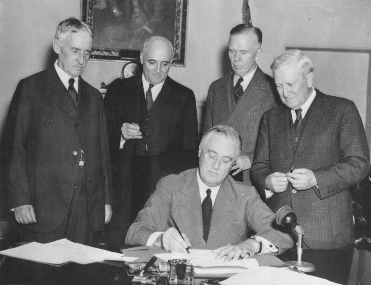 Andrew May with Henry Stimson, Morris Sheppard and George C. Marshall as President Roosevelt signs the Conscription Bill, 1940. (Photo Credit: Topical Press Agency / Getty Images)