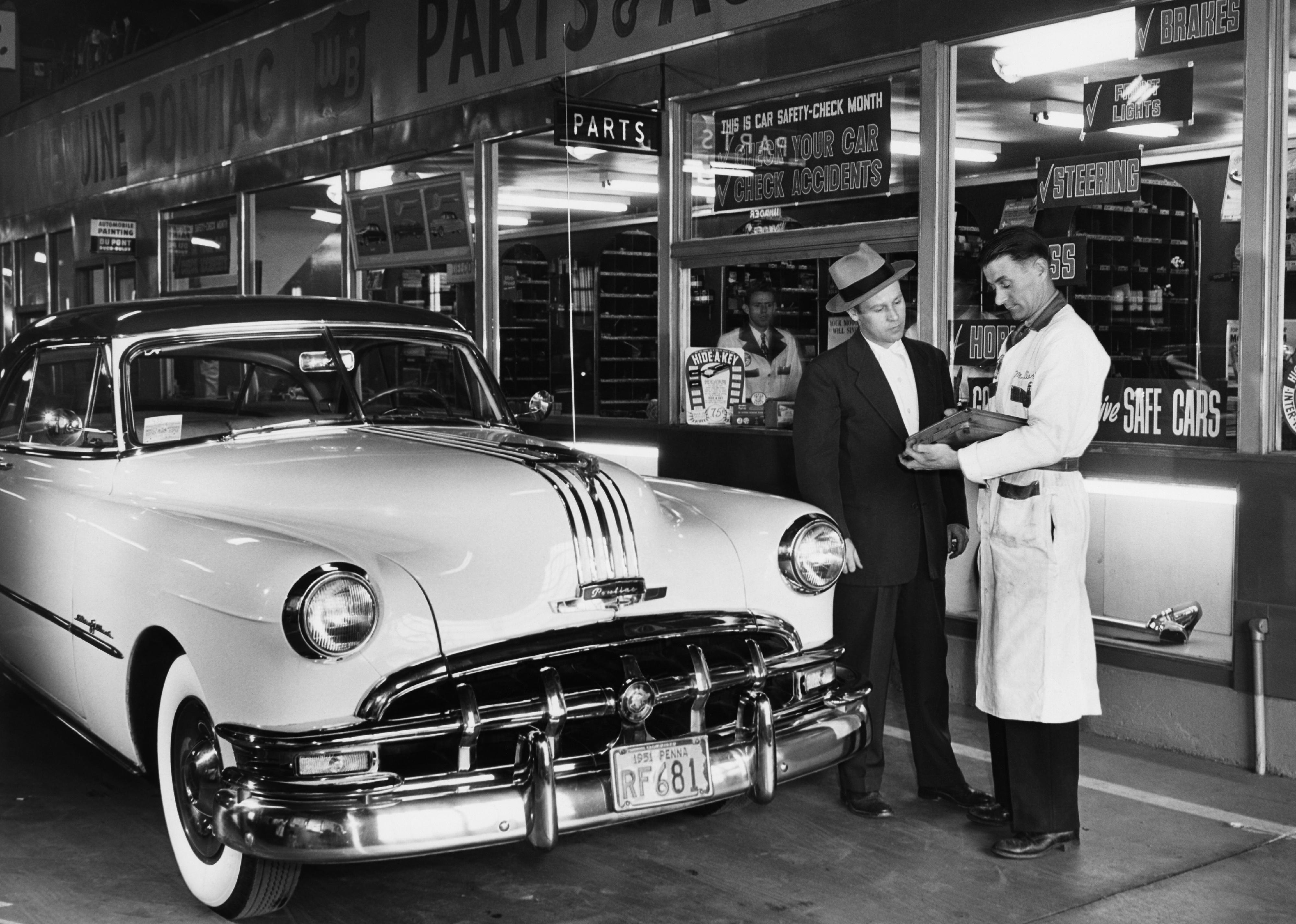 <p>An unlucky traveler discusses repair costs with a small-town mechanic in the early 1950s. AAA wouldn't establish its Approved Auto Repair program (which helps consumers identify reputable and affordable mechanics) until 1975, so drivers could only cross their fingers and hope they were getting a good deal.</p>