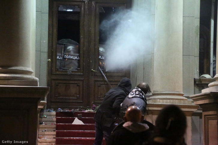 Rohamrendőrök barikádozzák tüntetők elől el a belgrádi városi tanács épületét 2023. december 24-én