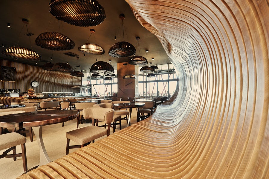 More than 1,300 pieces of plywood were used to construct the organic forms in this shop’s modern interior. The sculpted walls—along with coffee bean–shaped light fixtures and rippled tabletops—were crafted to conjure the feeling of being inside a sack of the caffeinated seeds. Local firm Innarch designed the plywood slats on the main wall to protrude outward, forming one long banquette.<p>Sign up for our newsletter to get the latest in design, decorating, celebrity style, shopping, and more.</p><a href="https://www.architecturaldigest.com/newsletter/subscribe?sourceCode=msnsend">Sign Up Now</a>