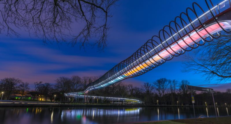 <p>Completed in 2015, the Slinky Springs to Fame is not a traditional tunnel but a pedestrian bridge with a spiral design resembling a slinky toy. Located in Oberhausen, Germany, it serves both artistic and functional purposes, providing a unique experience for pedestrians and cyclists crossing the Rhine-Herne Canal.</p>