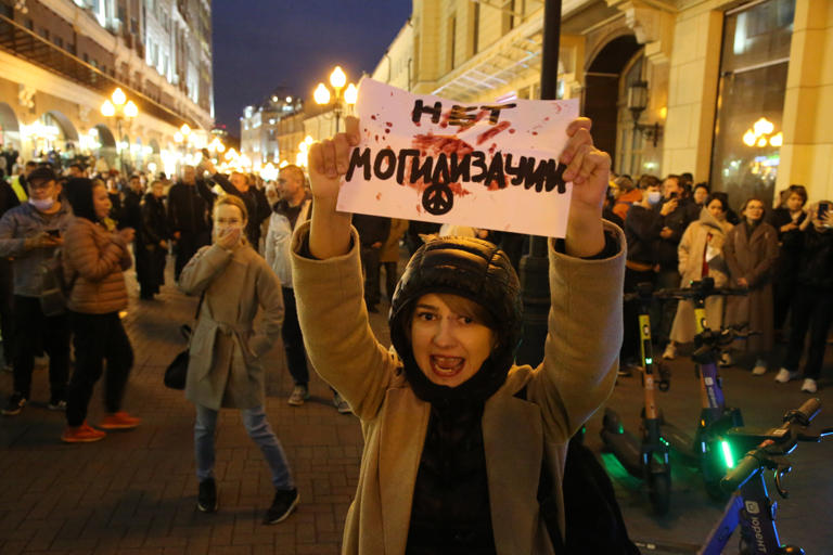 A female activist holding an anti-mobilization poster shouts slogan during an unsanctioned protest rally at Arbat street, on September 21, 2022, in Moscow, Russia. The sign "Net mogilizacii", written in Cyrilic means "No burialization".