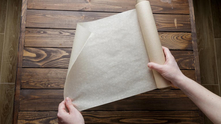 Person holding a roll of parchment paper