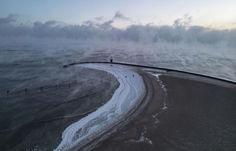 Ice forms on North Avenue Beach as steam rises off Lake Michigan during subzero temps on Jan. 14, 2024.