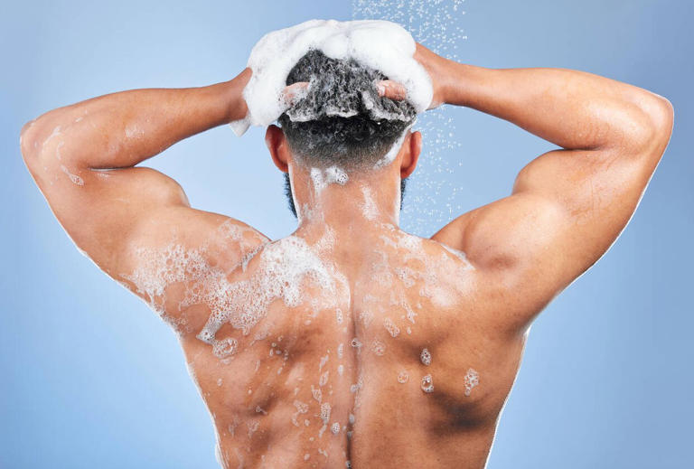 Un hombre de espaldas lavándose el pelo (iStock)