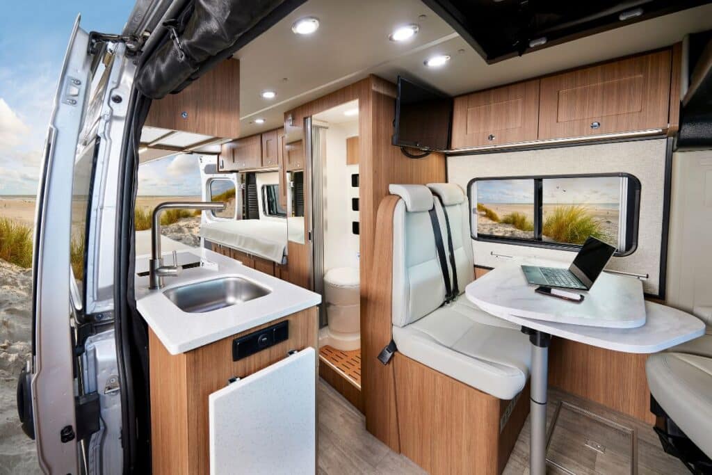 <p>The Roadtrek Pivot Slumber is a camper van built on the Ram Promaster Chassis with a sleek interior look. The Duo Space bathroom has a pivoting wall that creates a shower room and keeps the rest of the bathroom dry. We love this clever idea!</p><p>The dining table hides a swivel extension, so you can make it bigger at meal times or when you need to work on the go. Handy.</p><p>The pop top means you can sleep four people in this luxury campervan. </p>