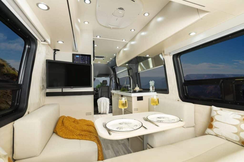 <p>The Pleasure-Way Plateau TS looks like a luxurious modern boat inside, thanks to the big windows, white cushions, and cream (Champagne) furniture.</p><p>Don’t worry – the upholstery also comes in flint, a better color for van lifers who regularly get muddy.</p><p>The guys at Pleasure-Way used every inch of space inside while keeping the furniture as big as possible. Great, innovative design.</p><p>The full kitchen is super long, the wardrobe is huge and the lounge is extra comfy. If you travel as a couple, this camper van definitely offers a glamorous camping experience.</p>