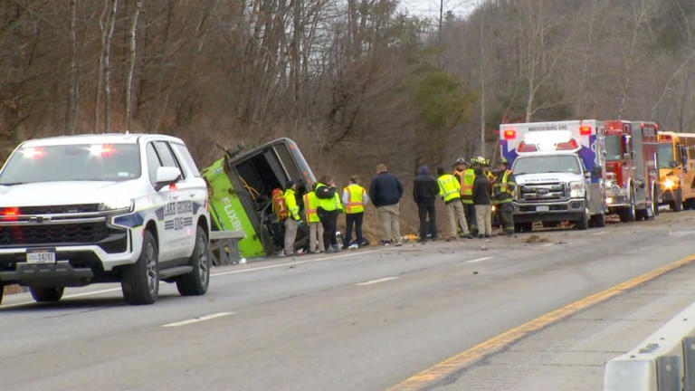 At least 1 dead, nearly two dozen injured after tour bus rolls over on highway