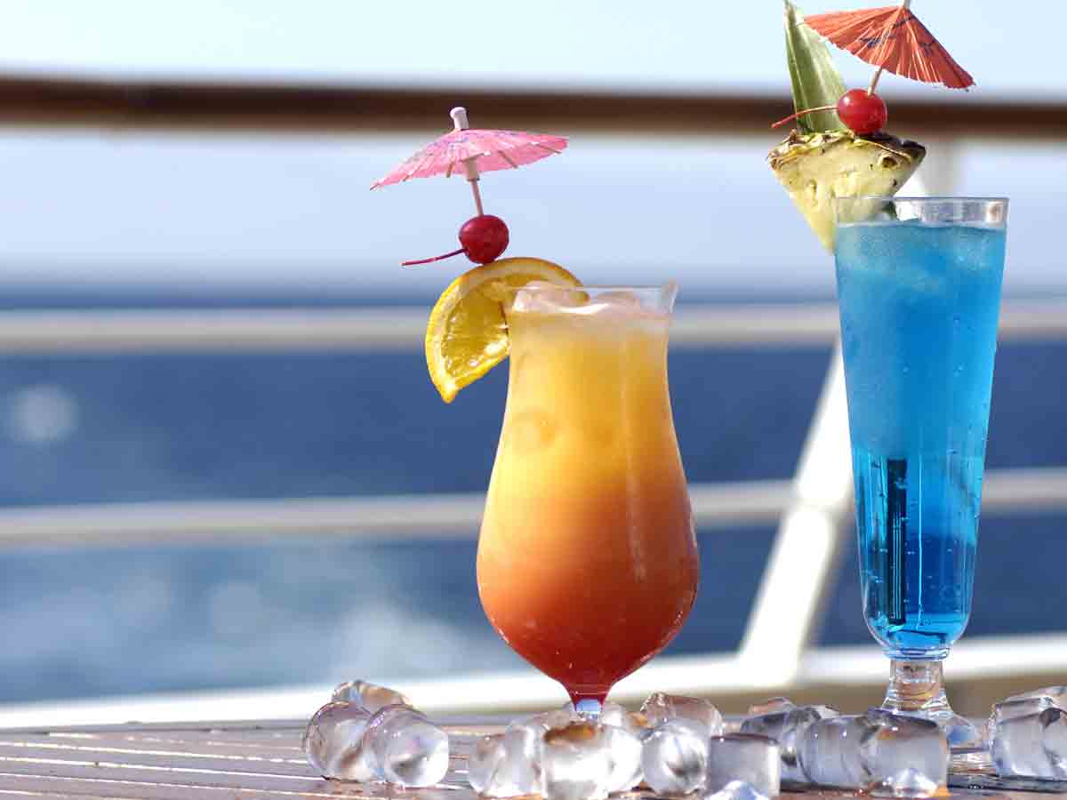 <p>You’re fantasizing about sipping the day away while sitting in a little deck chair watching the world go by with a fruity rum concoction. And in all honesty, some drinks are free on a cruise. </p> <p>But those are usually all non-alcoholic: tea, lemonade, water, and coffee.  The ship will have a cup to sell you for $10 for sodas. The alcoholic drinks can be fantastic, but be prepared to pay extra for them!</p>