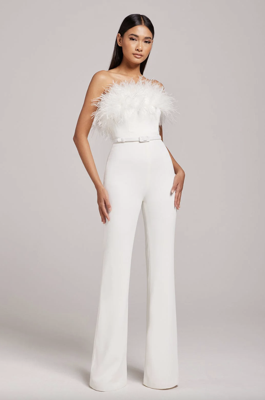 <p><strong>£395.00</strong></p><p><a href="https://www.nadinemerabi.com/products/colette-white-jumpsuit">Shop Now</a></p><p>Nadine Merabi's Collette wedding jumpsuit is perfect for playful bridal lewks. Crafted from smoothing crepe, this piece features a cute belt, fully boned <a href="https://www.cosmopolitan.com/uk/fashion/style/g30608797/corset-tops/">corset top</a> and a gorge feathered neckline. </p>