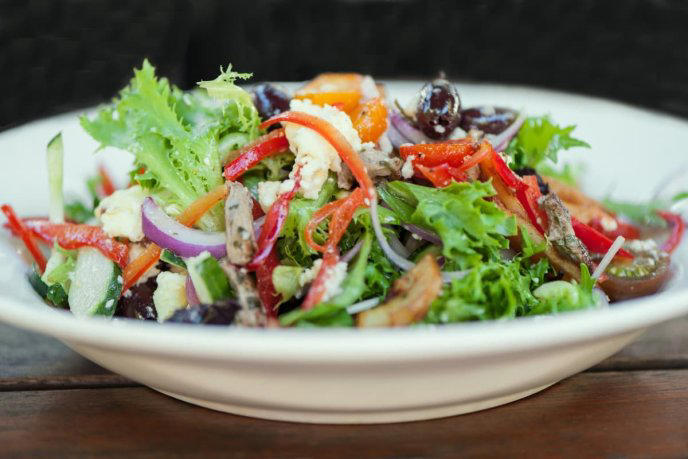 ensalada sobre plato blanco con verduras diversas