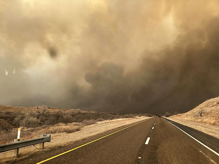 In this handout photo provided by the Texas A&M Forest Service, smoke billows over a road during the Smokehouse Creek fire on February 27, 2024 in the Texas panhandle. The fire has grown to cover approximately 500,000 acres.