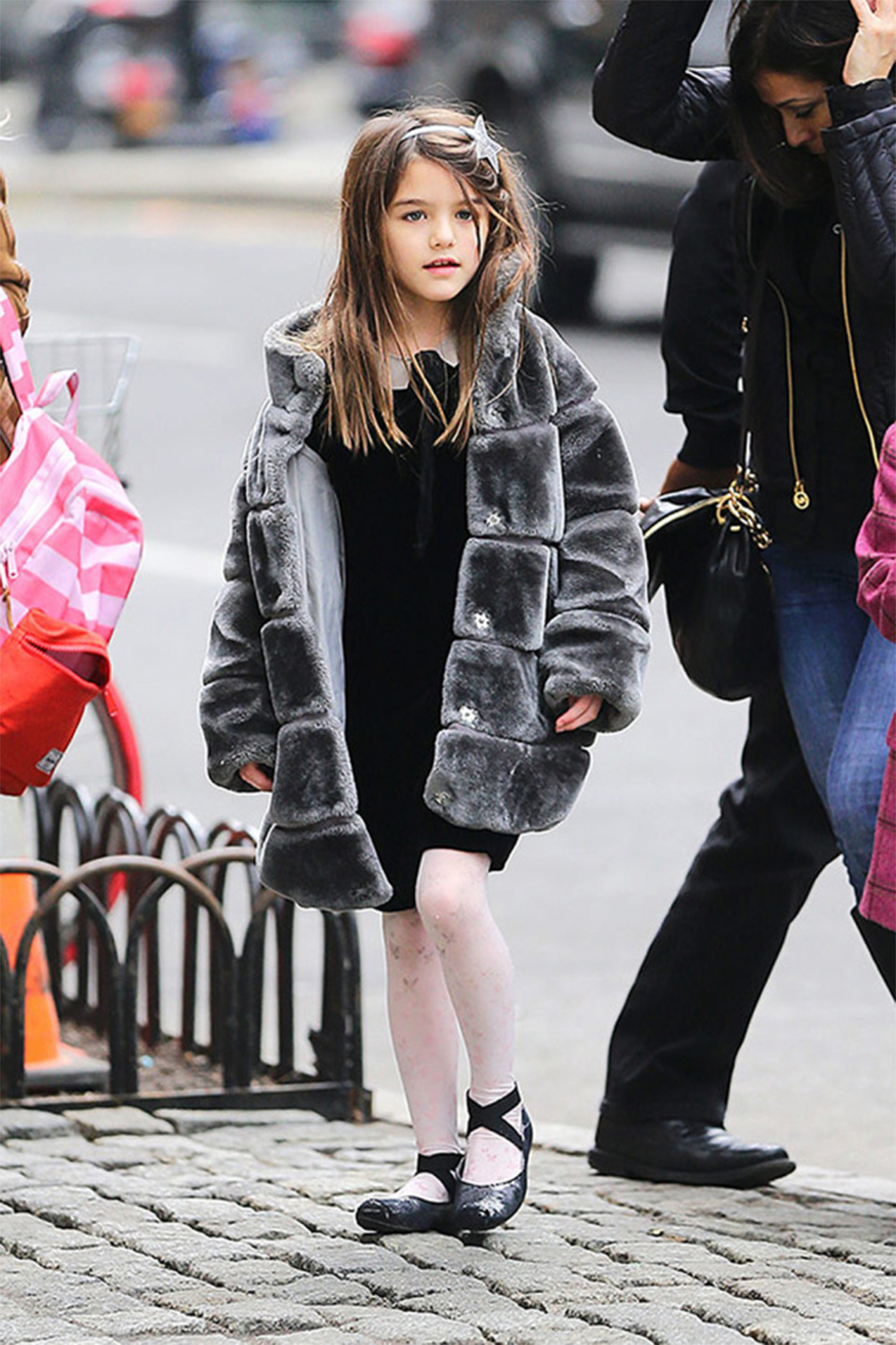 <p>Suri Cruise bundled up for some time out and about. The little girl wore a gray faux fur coat. </p>