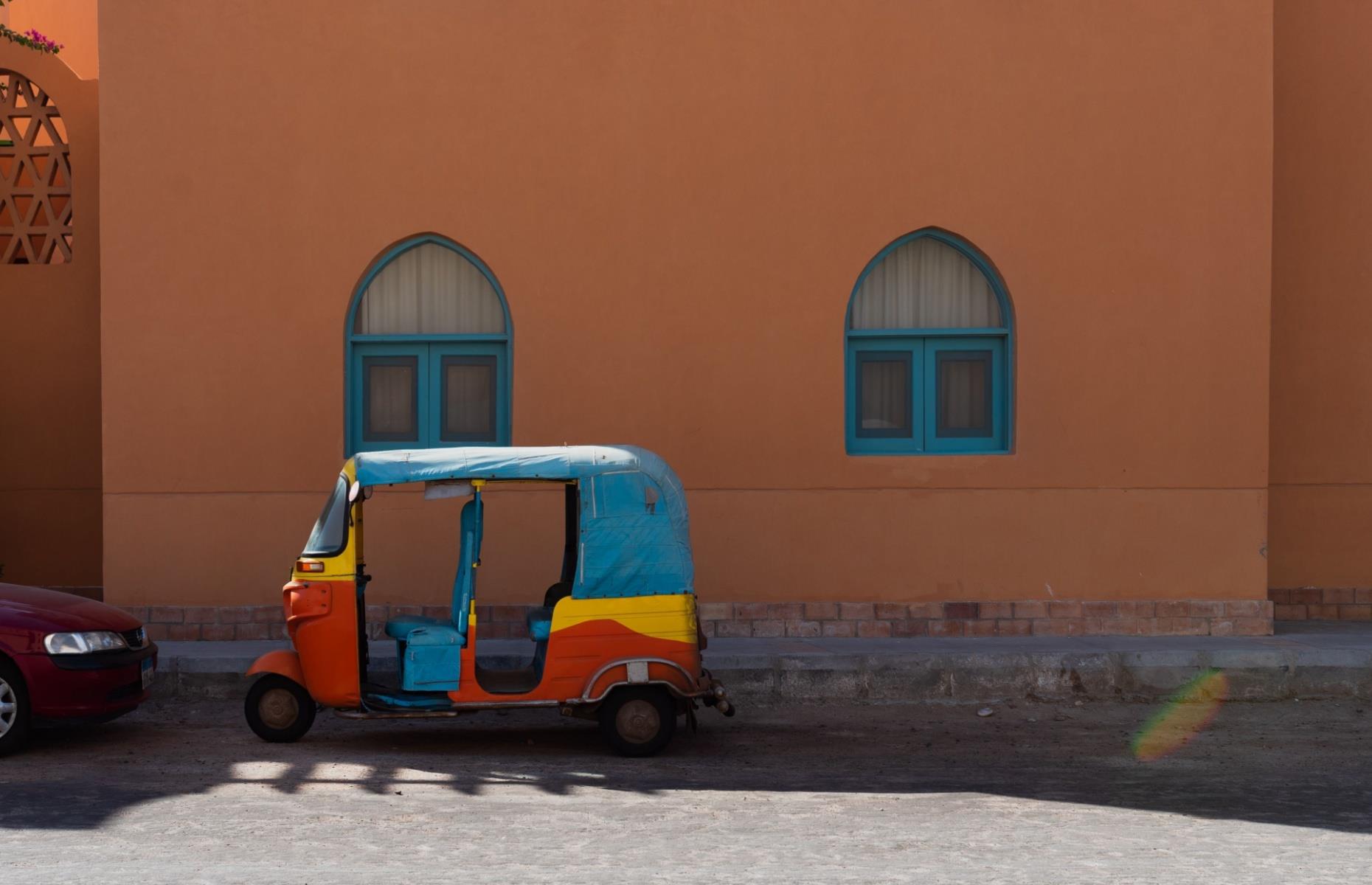 <p>A colorful quirk of El Gouna is that the most prominent method of transport, aside from cars, is the tuk-tuk. With a set journey price of 45 EGP each way (around 90¢), these motorised rickshaws also provide a cheap and easy way to hop around the town (nothing is very far away). Most offer cheap tours too – look for a sign in the cab, or just ask. Find them adding pops of pink, yellow and orange to the scene in downtown and Abu Tig Marina, or ask your hotel to call one for you. There are regular taxis too.</p>
