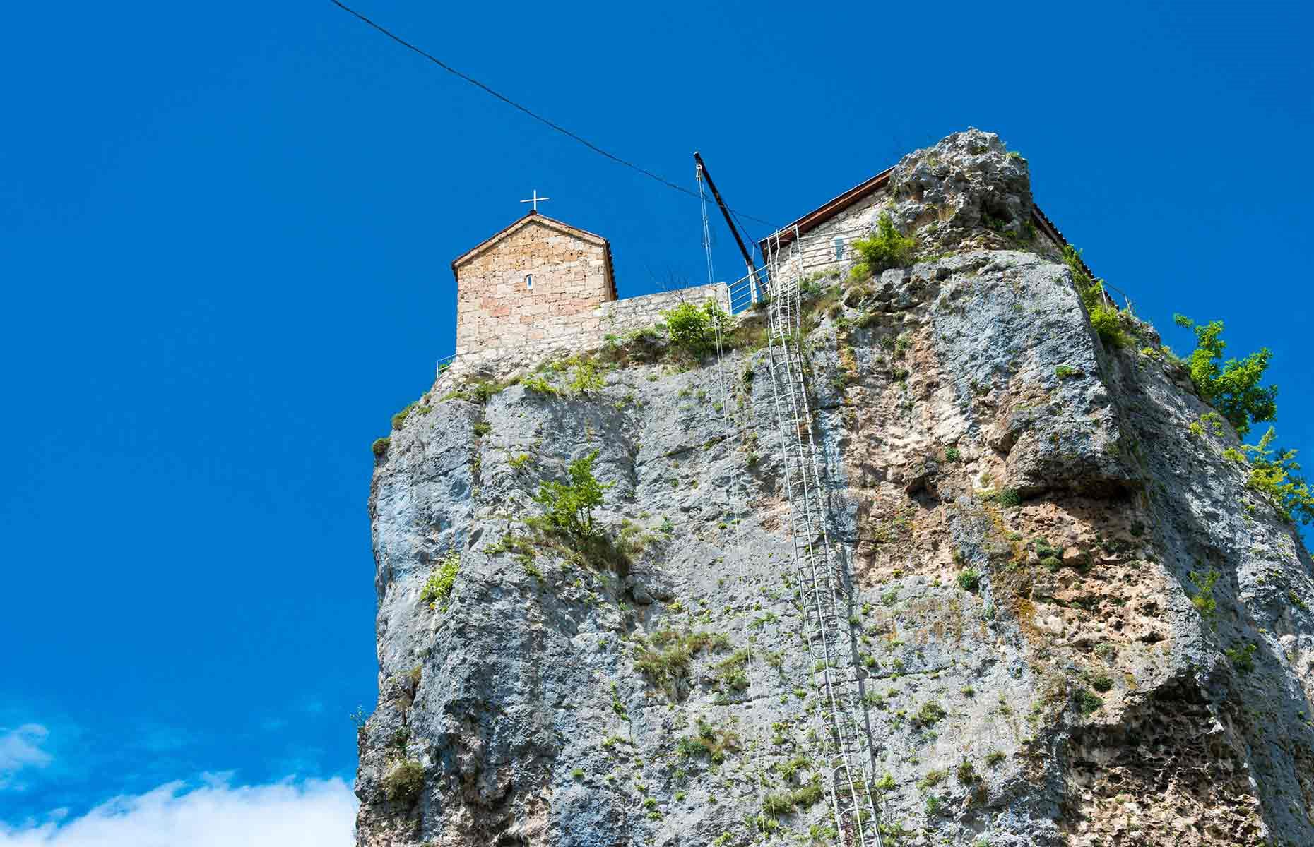 <p>Each day, monks living in the complex below would make the vertical climb up the pillar to the church to say prayers. Pictured here, the journey wasn't for the faint of heart. </p>  <p>Accommodation at the top of the pillar was kept modest and pared-back as a sign of devotion – Maxime, along with priests and monastery guests, would've broken bread in a simple dining space with bare plaster walls. </p>