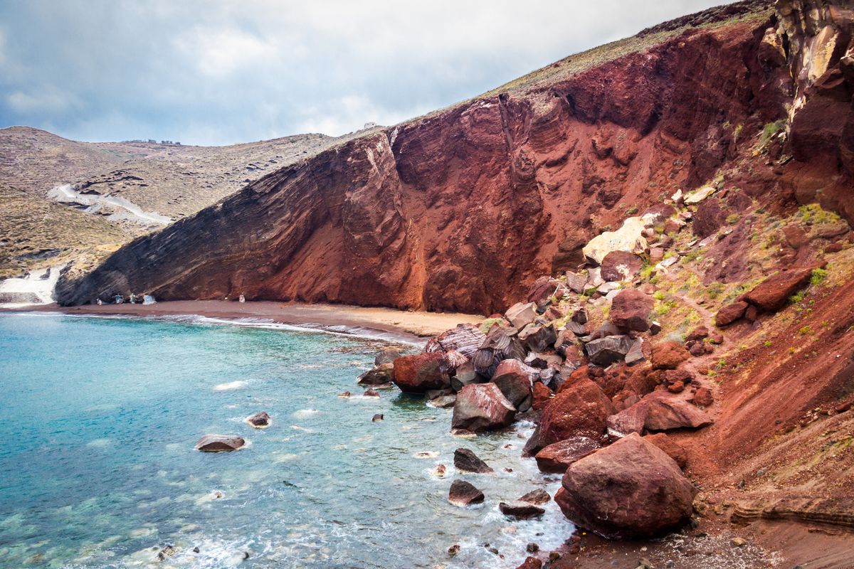 <p>Better dead than red? Not in Santorini! Come for the dramatic crimson landscape of Red Beach, where its towering lava cliff frames a crescent of dark sand on the Aegean.<br><br><a class="body-btn-link" href="https://go.redirectingat.com?id=74968X1553576&url=https%3A%2F%2Fwww.tripadvisor.com%2FAttraction_Review-g1189834-d641334-Reviews-Red_Beach-Akrotiri_Santorini_Cyclades_South_Aegean.html&sref=https%3A%2F%2Fwww.elledecor.com%2Flife-culture%2Ftravel%2Fg60369620%2Fbest-beaches-greece-guide%2F">Shop Now</a></p>