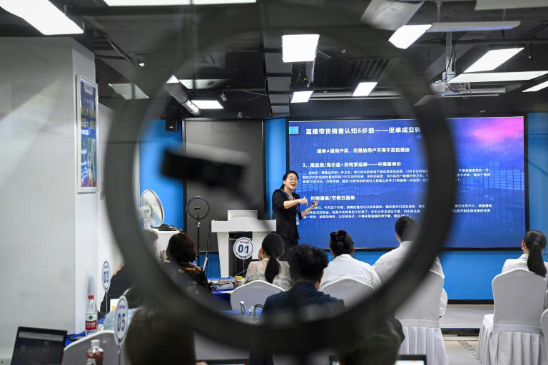 Una profesora explica a estudiantes cómo vender en línea, en Cantón, China, el 7 de abril de 2024