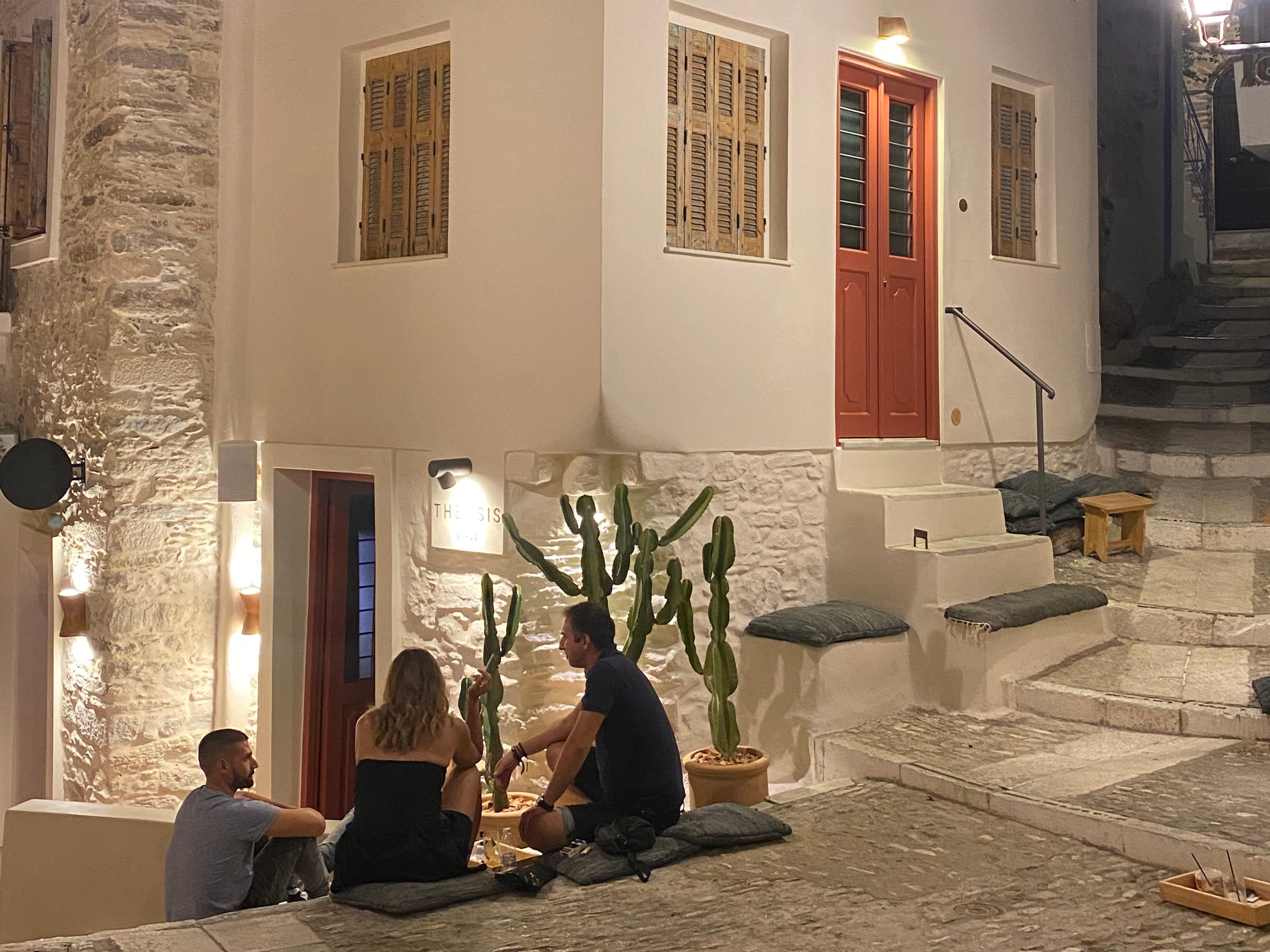 <p>Theosis Bar is a newer addition to Ano Syros. It's o<span>wned by the same man who operates Kouchico — one of the </span><a href="https://www.businessinsider.com/best-new-york-city-bars-impress-clients"><span>best cocktail bars</span></a><span> in Ermoupoli — and serves carefully curated and crafted drinks.</span></p><p><span>Instead of tables, people sit around a pedestrianized square on stairs and cushions, making the upscale atmosphere feel more casual and less stuffy.</span></p>