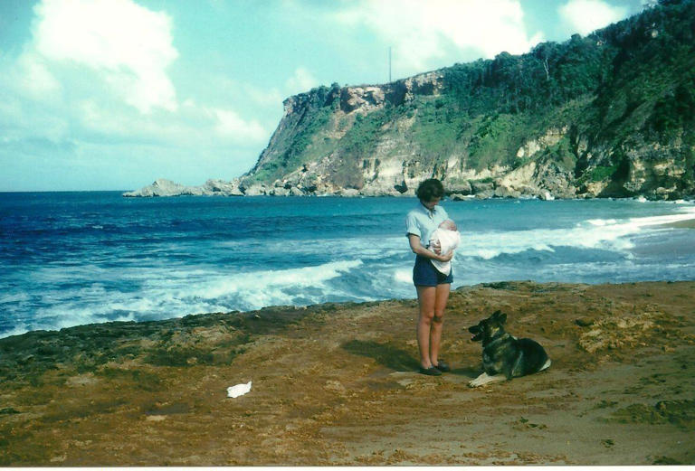 The writer as a baby in 1953, held by his mother on the shores of Puerto Rico, with their dog Carly.