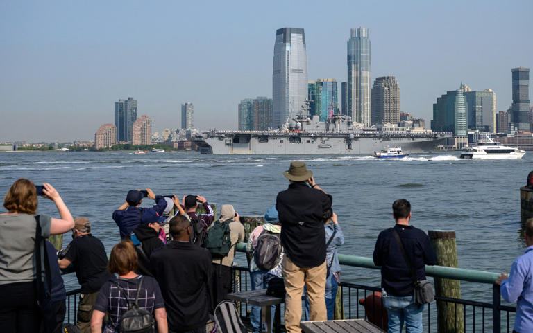 People watch as the USS Bataan, a Wasp-class amphibious assault ship sails through New York Harbor during Fleet Week on May 24, 2023. (Photo by ANGELA WEISS / AFP) (Photo by ANGELA WEISS/AFP via Getty Images)