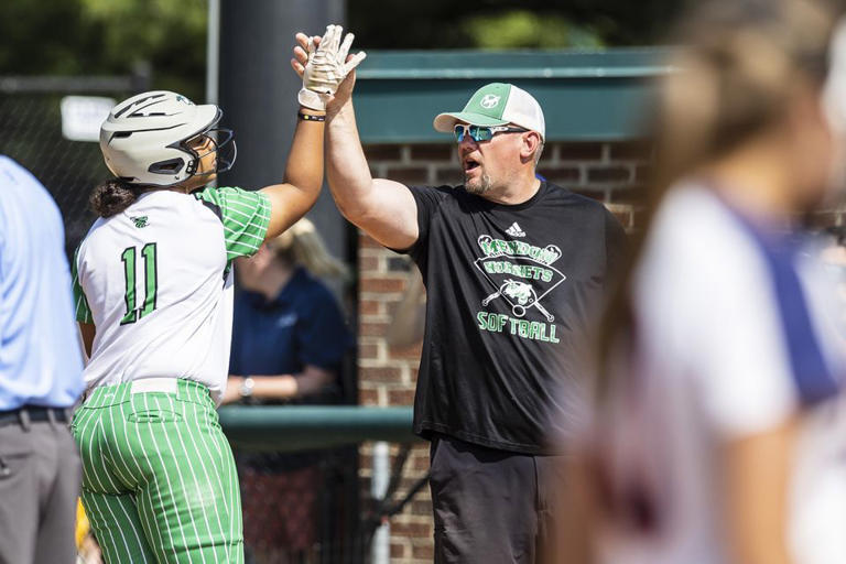 A Mendon coach high-fives Brielle Bailey (11) during the Division 4 championship softball game on Saturday, June 17, 2023.