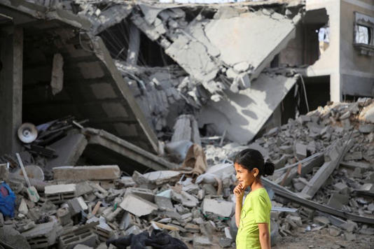 طفلة فلسطينية تقف وسط حطام منزل تدمر جراء الغارات الإسرائيلية على قطاع غزة في رفح يوم 25 أبريل نيسان 2024. تصوير: حاتم خالد - رويترز