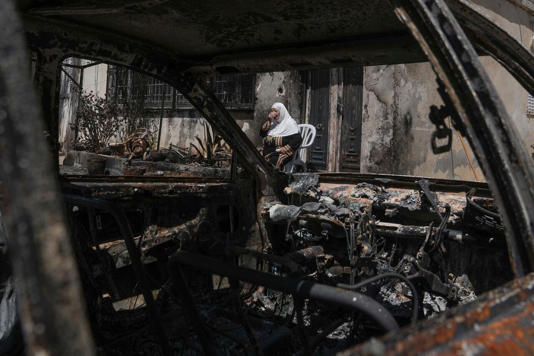 A Palestinian woman sits outside her torched home, days after it was set on fire by Jewish settlers, in the West Bank town of Turmus Ayya on Saturday, June 24, 2023. Israeli settlers entered the town, setting fire to Palestinian cars and homes after four Israelis were killed by Palestinian gunmen in the northern West Bank on Tuesday. (Mahmoud Illean/Associated Press)