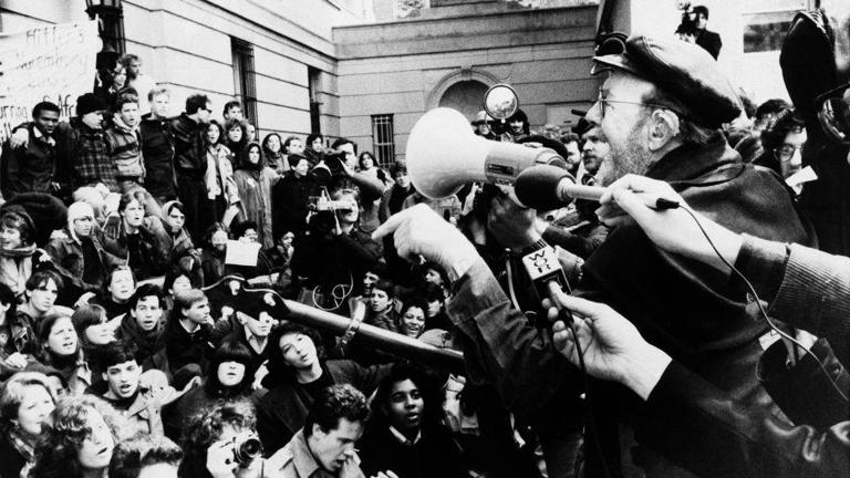 Pete Seeger, right, speaks to the crowd at Columbia University as hundreds of students continued to protest the school's ties to South Africa, April 8, 1985. The protests were against the university's South African investments. - Frankie Ziths/AP