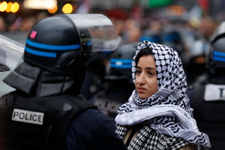 A protester faces a French police officer in riot gear during a pro-Palestine demonstration in central Paris on October 28, 2023. (Geoffroy van der Hasselt / AFP via Getty Images)