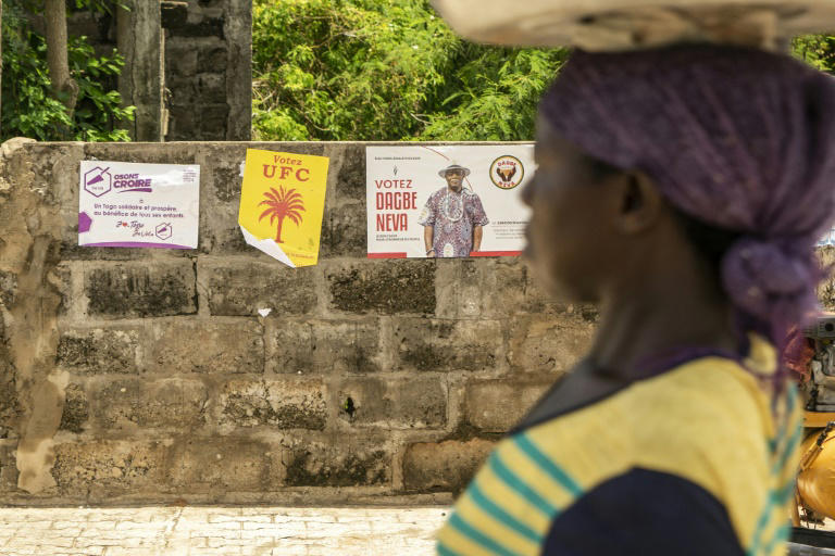 Une femme passe devant des affiches électorales dans la capitale togolaise Lomé le 24 avril 2024