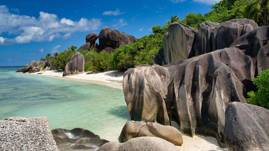 <p>With temperatures of 77°F (25°C) to 86°F (30°C) and a dry, not-so-humid climate, the Seychelles is a great May vacation destination, especially if you need to relax and unwind. Luckily, the Seychelles is home to some incredible tropical beaches, Anse Source d’Argent on La Digue Island being one of the best.</p><p>An incredibly photogenic destination, this beach is cloaked in sparkling white sand and dotted with enormous granite boulders. With tall, lush green palm trees and transparent turquoise waters to go with it, you’re in for a real treat. To enjoy the beach, find a <a href="https://worldwildschooling.com/hidden-beaches-in-the-world/">secluded spot</a> and relax, or grab a kayak and paddle around the island.</p><p class="has-text-align-center has-medium-font-size">Read also: <a href="https://worldwildschooling.com/underrated-tropical-vacation-destinations/">Underrated Tropical Destinations</a></p>