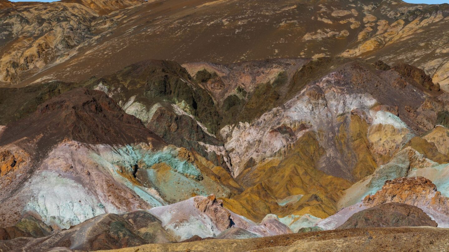 <p>This spot in California's Death Valley is like walking into a <a href="https://www.nps.gov/places/artists-palette.htm">live painting</a>. The cliffs here are streaked with colors like rust, blue, and white, thanks to minerals from long-gone volcanic eruptions. Once you look at this landmark, you won’t even believe that it’s real – that’s how beautiful it is.</p>