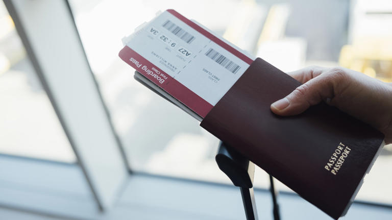 Person holding their passport and boarding pass