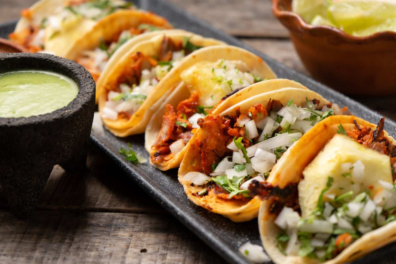 Image Credit: Shutterstock / Guajillo studio <p><span>A glorious result of Lebanese immigrants in Mexico, these tacos feature spit-grilled pork served on corn tortillas, garnished with pineapple, onions, and cilantro. A bite of history in every bite!</span></p>