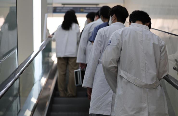 Doctors take an escalator at a hospital in Daegu, Tuesday. Newsis 