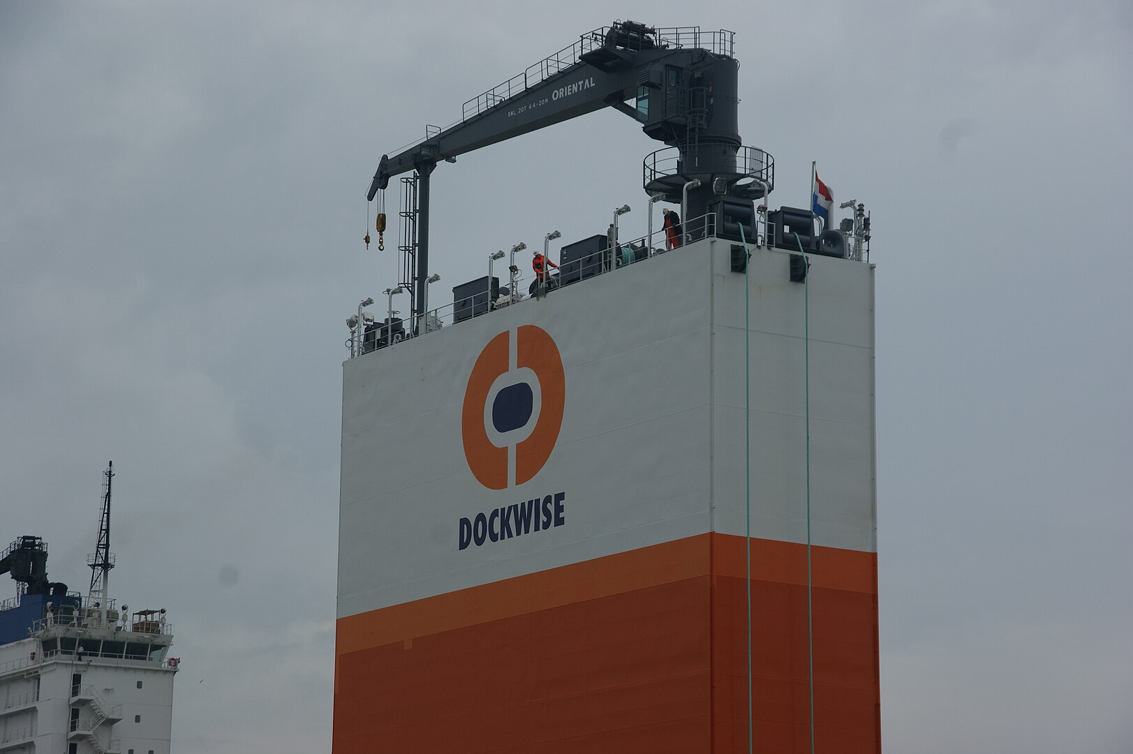 <p>The Dockwise Vanguard operates by taking on water as a ballast, allowing it to sink slightly and creating a space in its docking bay where it can then maneuver a ship in to secure it.</p>  <p>Once secured, the ship pumps out the ballast and lifts the other ship out of the water, safely within the Dockwise Vanguard.</p>