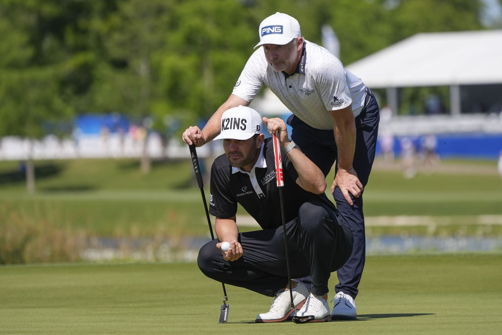 <p>Callum Tarren, of England, lines up his putt with teammate David Skinns, of England, standing, during the second round of the PGA Zurich Classic golf tournament at TPC Louisiana in Avondale, La., Friday, April 26, 2024. </p>