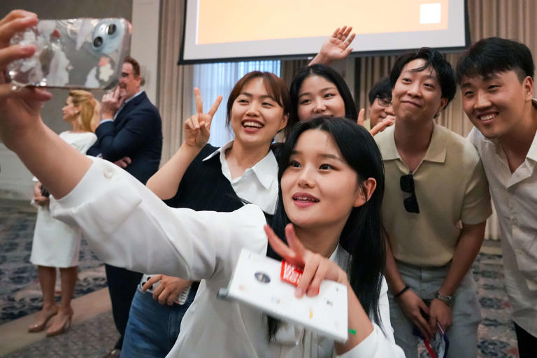 Lily Jo takes a selfie with fellow North Korean refugees Grace Kang (left) and Bella Ha alongside event guests after speaking during the A Path to Peace: The Hopeful Hearts of North Korea event at SMU on Monday, April 29, 2024.